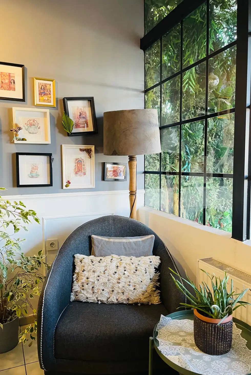 An inviting corner with an armchair, plants and wall art beside a window
