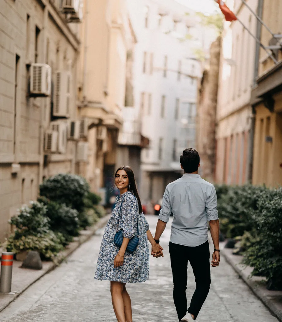 Married couple holding hands while walking together outdoors