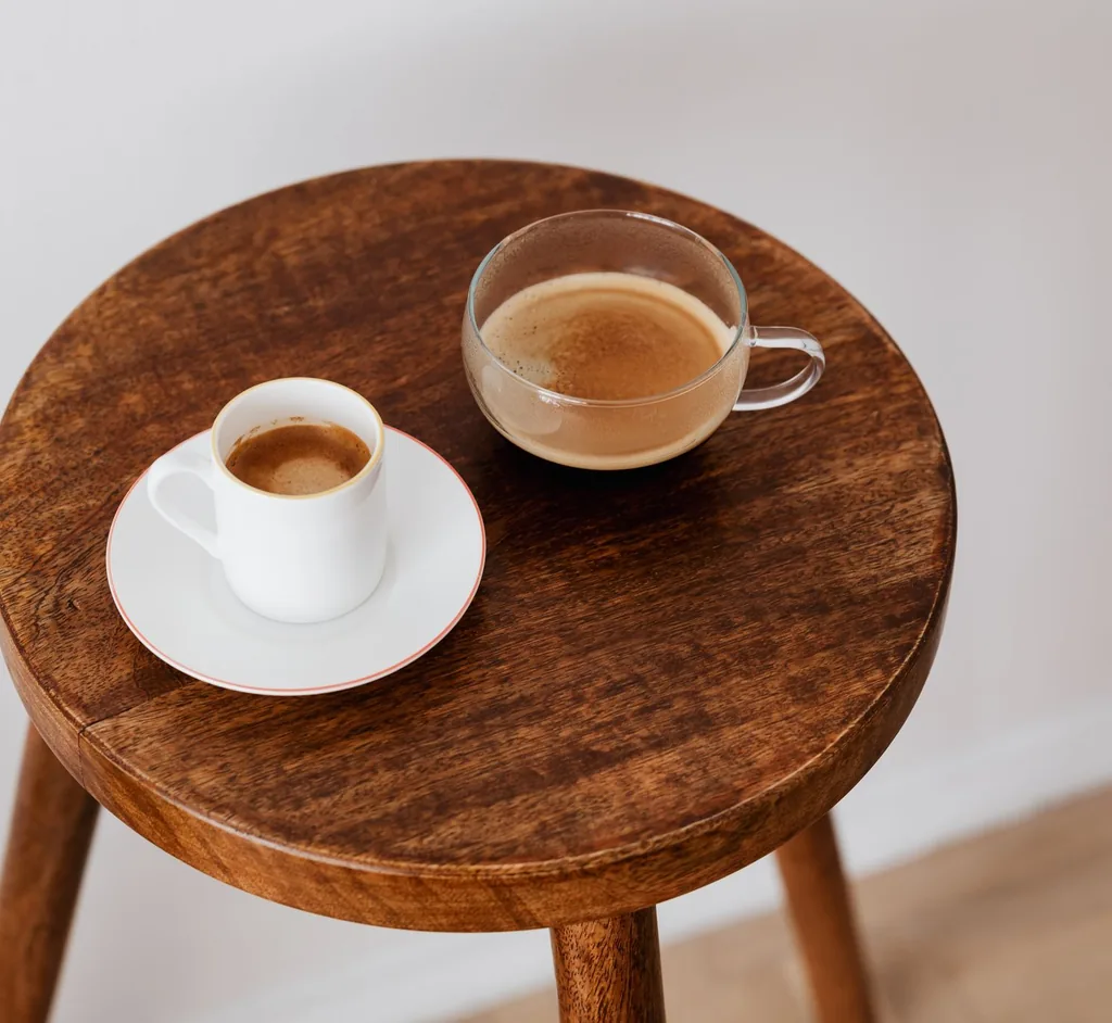 Two cups of coffee side by side in a warm indoor setting