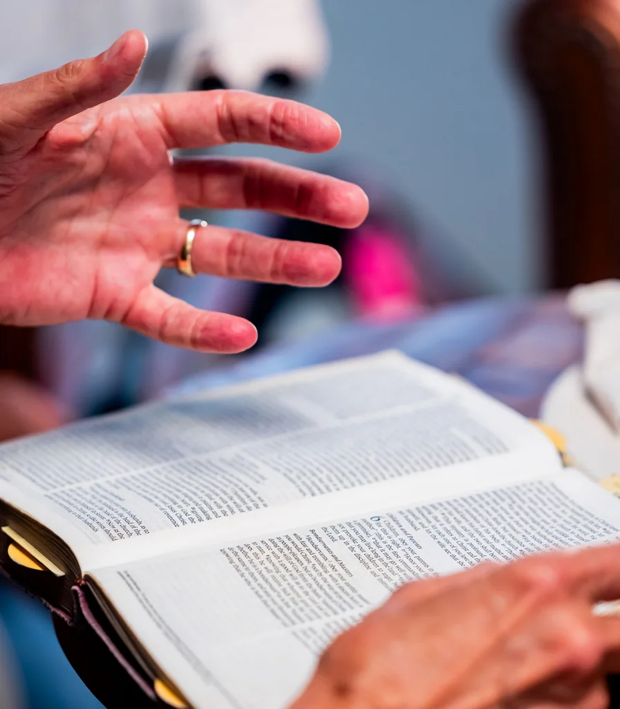 Hands resting on an open Bible during faith-integrated counseling