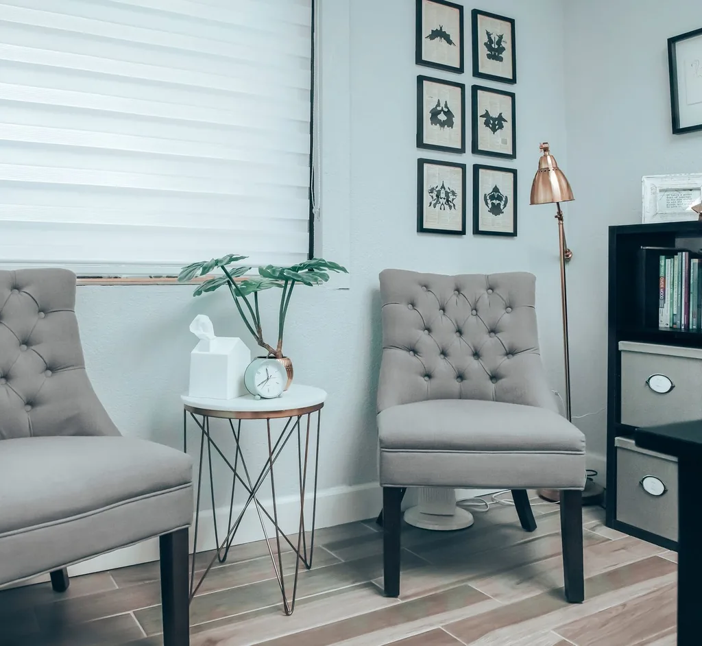 A bright sitting room with comfortable chairs and a bookshelf