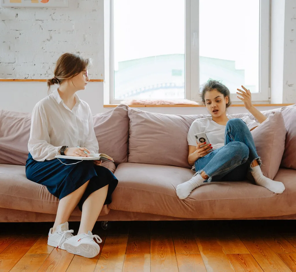 Teenager talking with a counselor on a comfortable sofa during therapy