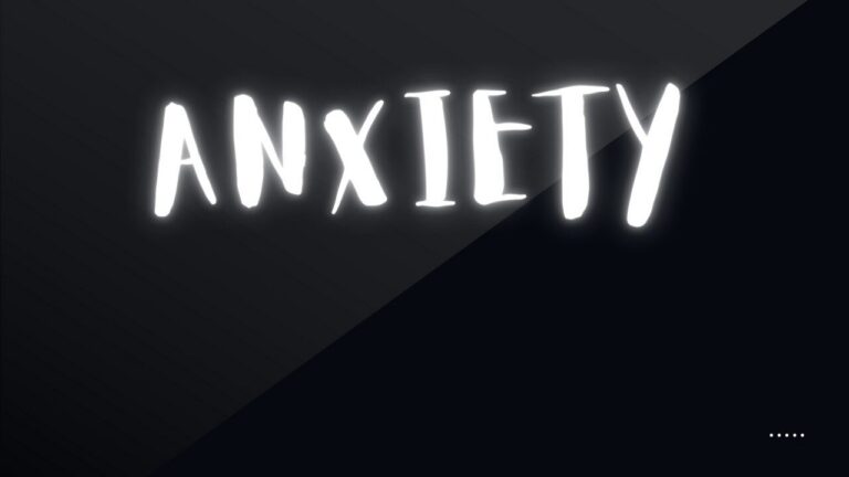 The word anxiety glowing in white hand-drawn letters on a dark background